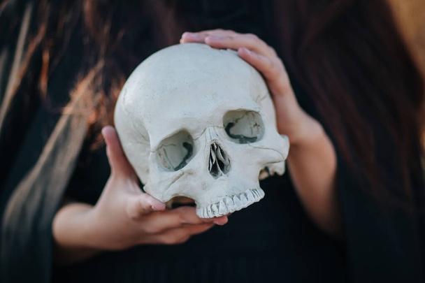 Skull in the hands close up. Witchcraft, necromancy. The concept of Halloween, a ritual of black magic. - Fotoğraf, Görsel