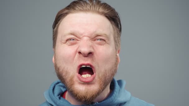 Video van schreeuwende blonde man in blauwe sweater, portret - Video