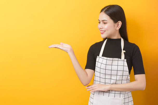 Happy female cook portrait on yellow background  - 写真・画像