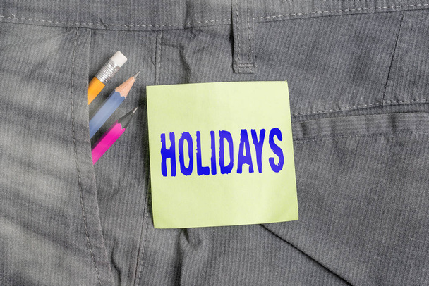 Writing note showing Holidays. Business photo showcasing an extended period of leisure and recreation spent away from home Writing equipment and green note paper in pocket of trousers. - Photo, Image
