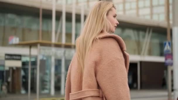 Voltar vista tiro de menina loira lindo no casaco sonhadoramente andando pelo centro da cidade
 - Filmagem, Vídeo