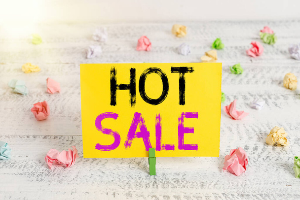 Text sign showing Hot Sale. Conceptual photo putting products on high discount Great price Black Friday Green clothespin white wood background colored paper reminder office supply. - Photo, Image