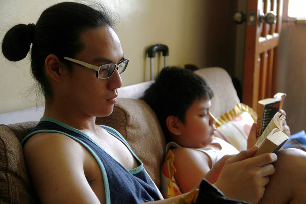 Photo de jeunes garçons philippins lisant des livres pour passer le temps pendant le confinement en raison de l'épidémie du virus Covid 19
. - Photo, image