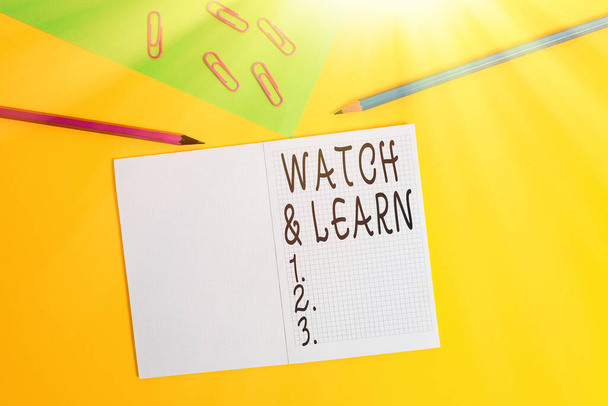 Konceptualne pismo ręczne pokazujące Watch And Learn. Business photo showcasing pokazujące działanie lub pomysły, jak zrobić rzeczy Blank notebook ołówki marker papier arkusz kolorowe tło. - Zdjęcie, obraz