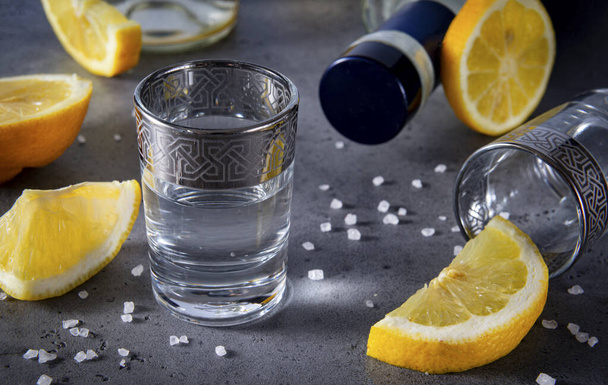 shot of tequila with lemon slices with salt on a gray background, a strong alcoholic drink, vodka - Foto, immagini