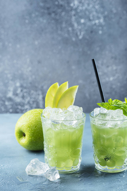 Green cocktail with ice and mint. Bar concept. Apple mojito with mint and ice on the blue background, selective focus image - Fotografie, Obrázek