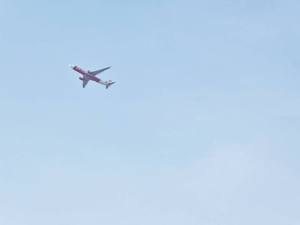 BANGKOK THAILAND-08 APRIL 2019Air Asia's aircraft flew in the sky in the distance. - Photo, Image