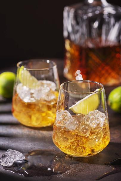 Cuban strong rum with ice and lime, summer concept with a strong shadows, selective focus image - 写真・画像