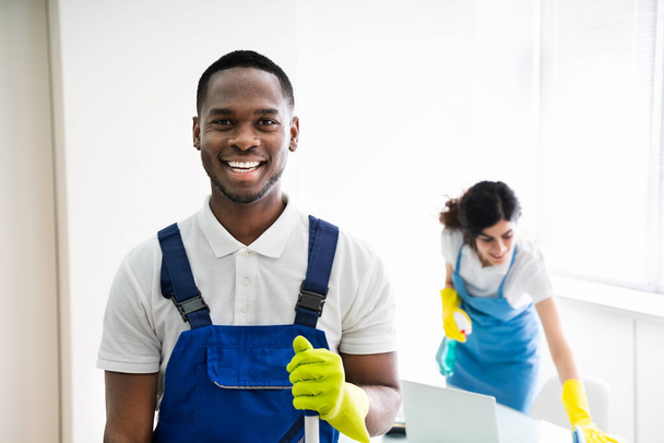 Портрет счастливого уборщика с оборудованием для уборки в офисе
 - Фото, изображение