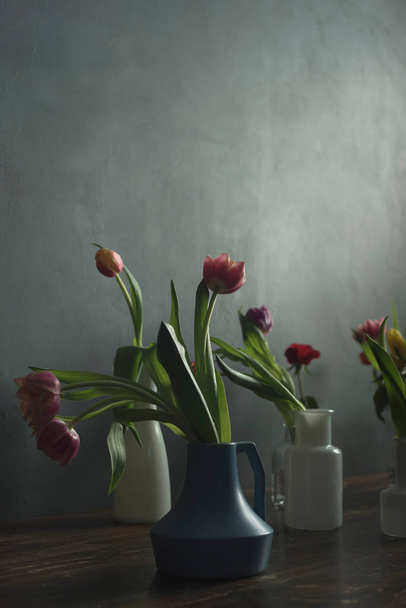 Modrobílé vázy s tulipány na dřevěném stole. - Fotografie, Obrázek