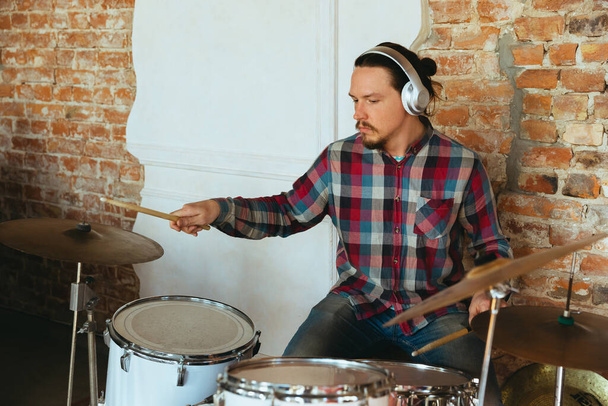 Caucasian musician playing drumms during online concert with the band at home isolated and quarantined, inspired improvising - Φωτογραφία, εικόνα