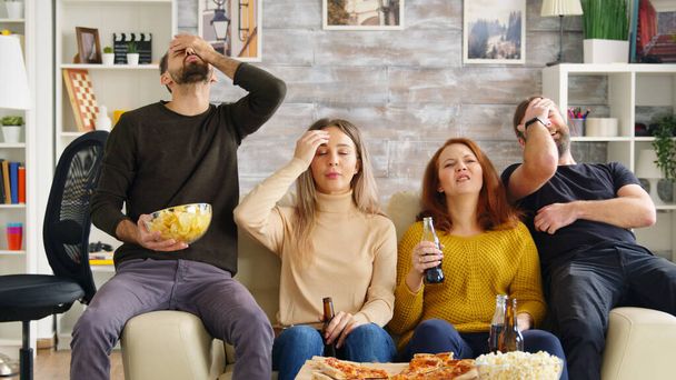 Two couples cheering up while watching a football match on tv - Photo, Image