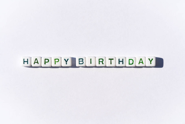 Cartão postal feliz aniversário com cubos com letras verdes sobre fundo branco
 - Foto, Imagem