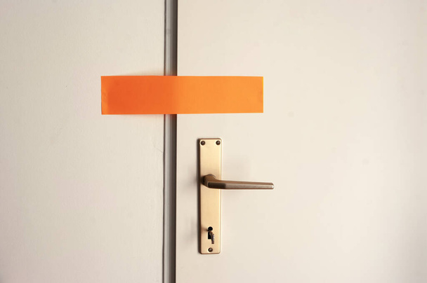 Foto-Attrappe, Kopierraum, verschlossene Tür mit orangefarbenem Aufkleberpapier, Quarantäne, Schutz. - Foto, Bild