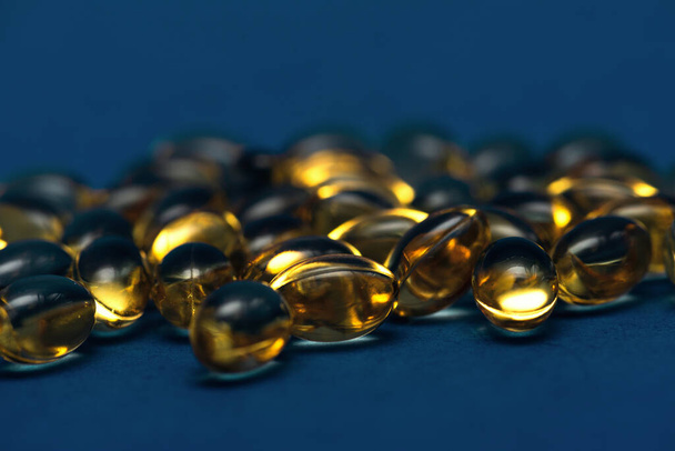 Vitamíny ležící na modrém pozadí. Omega rybí tuk - Fotografie, Obrázek