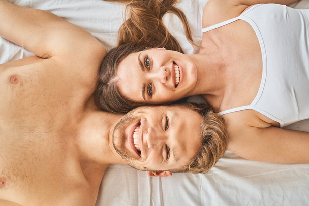 Top view of young people that lying on bed - Fotoğraf, Görsel
