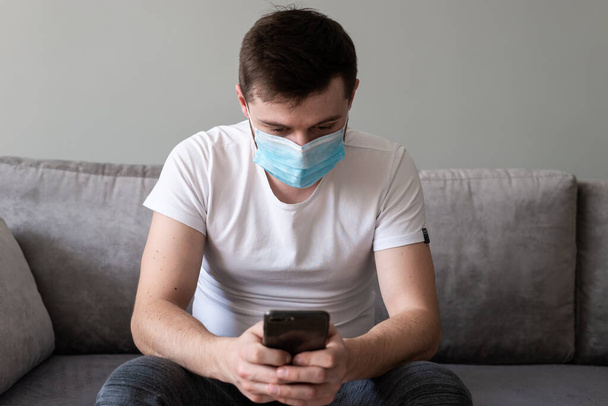COVID-19 Pandemic Coronavirus; Man wearing face mask protective for spreading of Coronavirus Disease and talking on mobile phone. Portrait of man with surgical mask on face against SARS-CoV-2. - Foto, Imagem