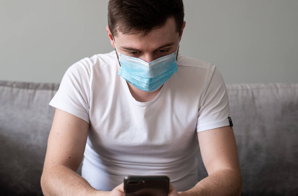 COVID-19 Pandemic Coronavirus; Man wearing face mask protective for spreading of Coronavirus Disease and talking on mobile phone. Portrait of man with surgical mask on face against SARS-CoV-2. - Фото, зображення