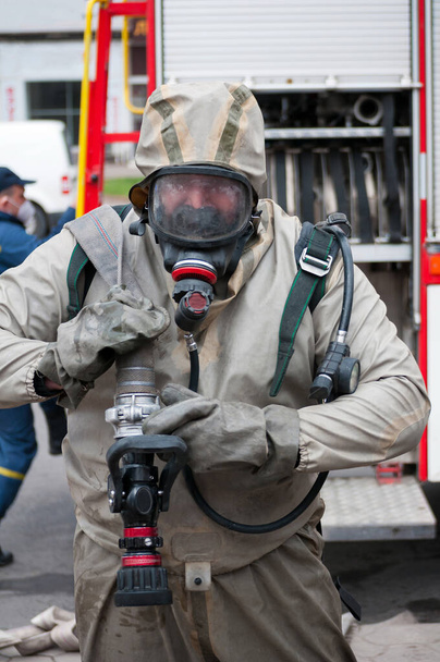 reddingsteam desinfecteert straat met speciale ontsmettende vloeistof oplossing terwijl covid-19 ramp van brandweerauto - Foto, afbeelding