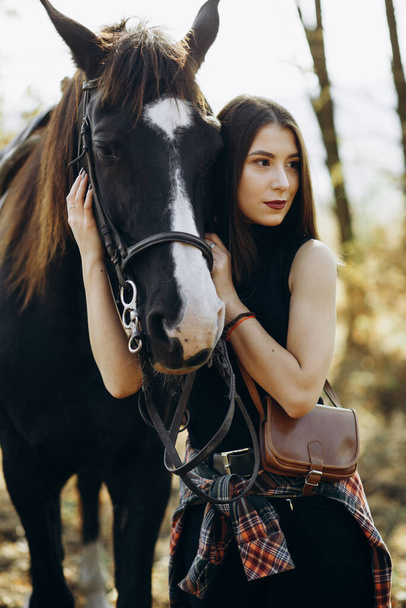 Νεαρή γυναίκα με το άλογό της στη λέσχη. Στυλ ράντσου - Φωτογραφία, εικόνα
