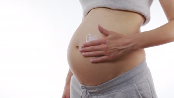 Κοντινό πλάνο της εγκύου γυναίκα εφαρμόσει κρέμα περιποίησης του δέρματος στην κοιλιά έγκυος. 6ια. - Πλάνα, βίντεο