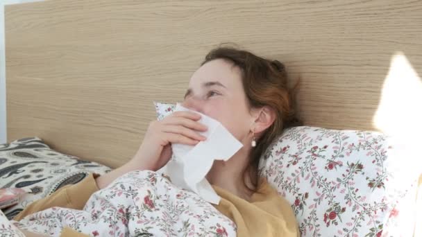 Kranke Mädchen niesen, pusten, Nase mit Seidenpapier wischen. Frau hustet im Bett - Filmmaterial, Video