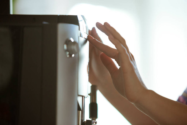 Close up of female hands making coffee on coffee-machine at home or cafe - Foto, imagen