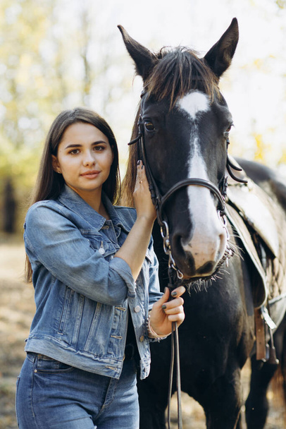 Porträt einer jungen Frau mit ihrem Pferd im Country Club. Ranch-Stil. Mädchen schaut in die Kamera - Foto, Bild