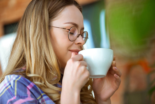 Close up of beautiful joyful woman drinking coffee at home - Fotografie, Obrázek