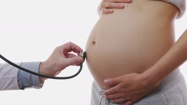 Közelkép a női orvos vizsgálata terhes nő sztetoszkóppal, 6k. - Felvétel, videó