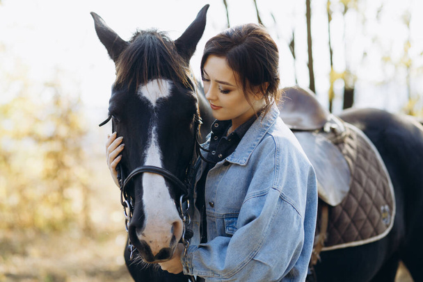 田舎のクラブで馬と一緒に若い女性。牧場風 - 写真・画像