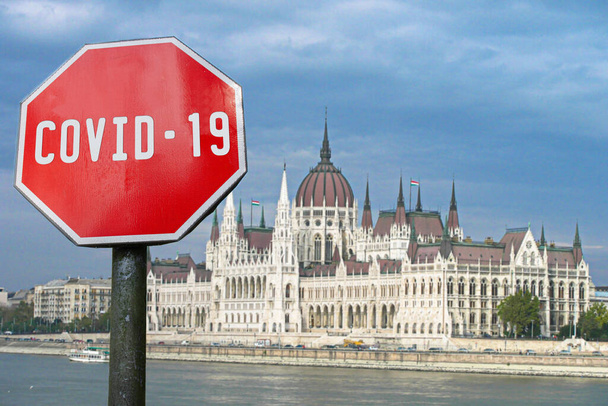 Covid-19 assina com o edifício do parlamento em Budapeste, Hungria. Conceito de surto pandémico de coronavírus
. - Foto, Imagem