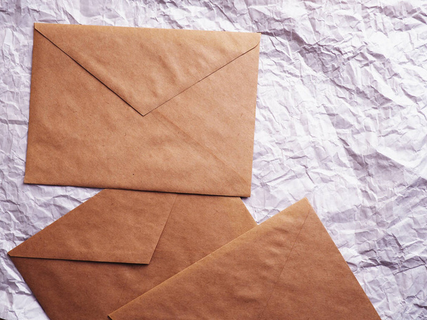 Envelope of Kraft paper lies on crumpled paper. Note from a paper on a cord of an envelope from kraft paper. - Photo, Image