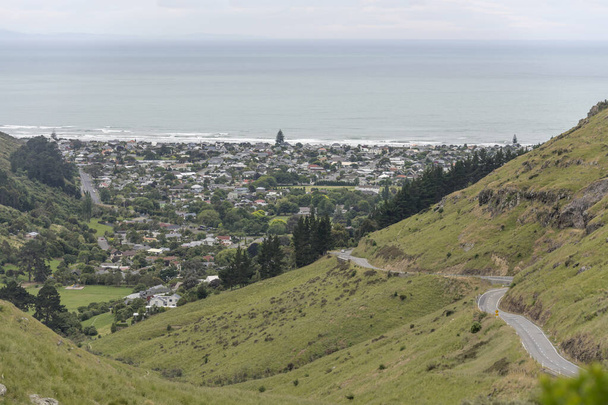 kronkelende weg op groene heuvels rond Sumner borough bij Ocean shore, geschoten in fel bewolkt licht, Christchurch, South Island, Nieuw-Zeeland - Foto, afbeelding