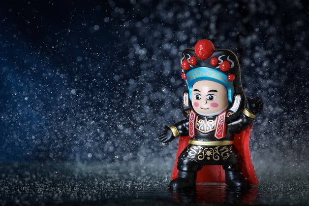 Brinquedo em um vestido chinês tradicional com gotas de água em um fundo. Vestuário tradicional
 - Foto, Imagem