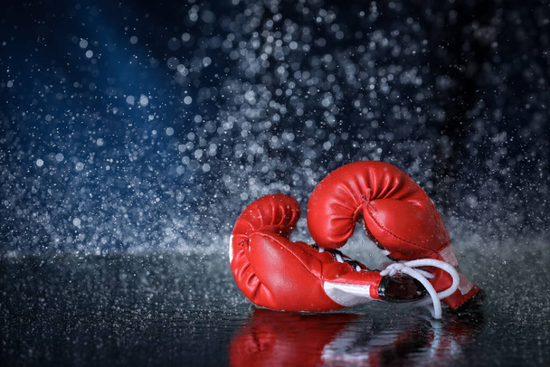 Red boxing gloves on a water drops background.  Sport lifestyle. Motivation. Goal achievement. Protect yourself - Photo, Image