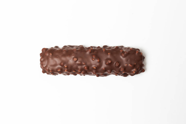 barra de chocolate con chocolate marrón oscuro con nueces sobre un fondo blanco
. - Foto, imagen