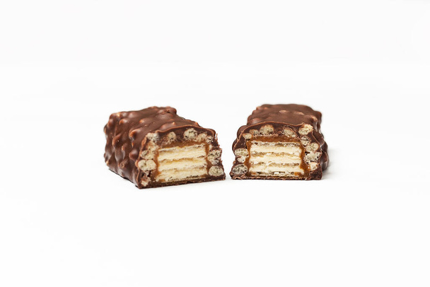 krájená čokoládová tyčinka s tmavě hnědou čokoládou s ořechy na bílém pozadí. - Fotografie, Obrázek