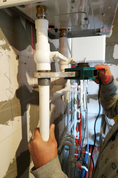 Calentador de agua doméstico de dos circuitos y conexiones de plomería.2020
 - Foto, Imagen