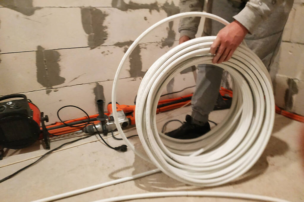 Underfloor heating is mounted on a pipeline installer, heating system and underfloor heating.2020 - Photo, Image