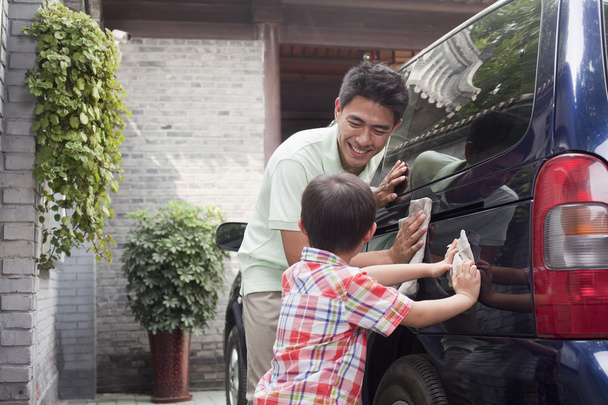Vater und Sohn putzen gemeinsam ihren Minivan - Foto, Bild