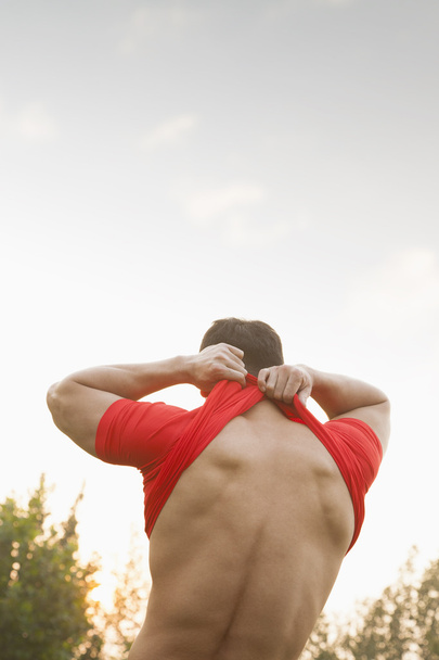Muscular Man Taking Off His Shirt - Photo, Image