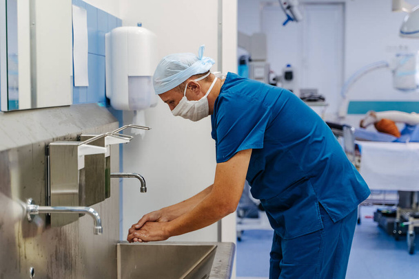 Doctor disinfects hands. Medical specialist washes hands. Surgery. - Foto, afbeelding