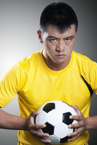 Jugador de fútbol sosteniendo una pelota de fútbol
 - Foto, Imagen