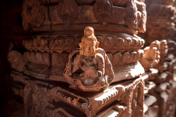 Aziatische figuur gesneden in houten kolom binnen tempel in Kathmandu - Foto, afbeelding