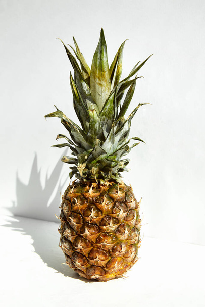 Whole ripe tropical pineapple with shadow on a white background. - Фото, зображення