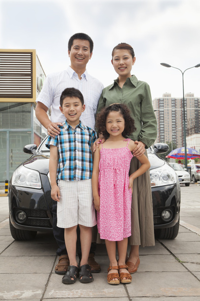 οικογένεια που είναι χαμογελώντας μπροστά από το αυτοκίνητο - Φωτογραφία, εικόνα