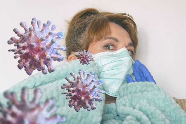 Donna spaventata seduta a casa indossando una maschera protettiva e guanti. Concetto di paura pandemica da coronavirus - Foto, immagini