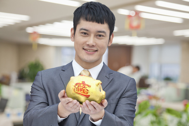 Hombre de negocios sosteniendo alcancía china
 - Foto, imagen