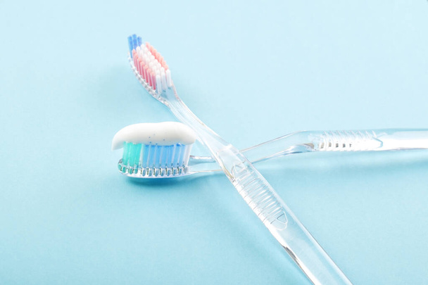 Toothbrush with toothpaste on blue background. Tooth cleaning concept.  - Photo, Image
